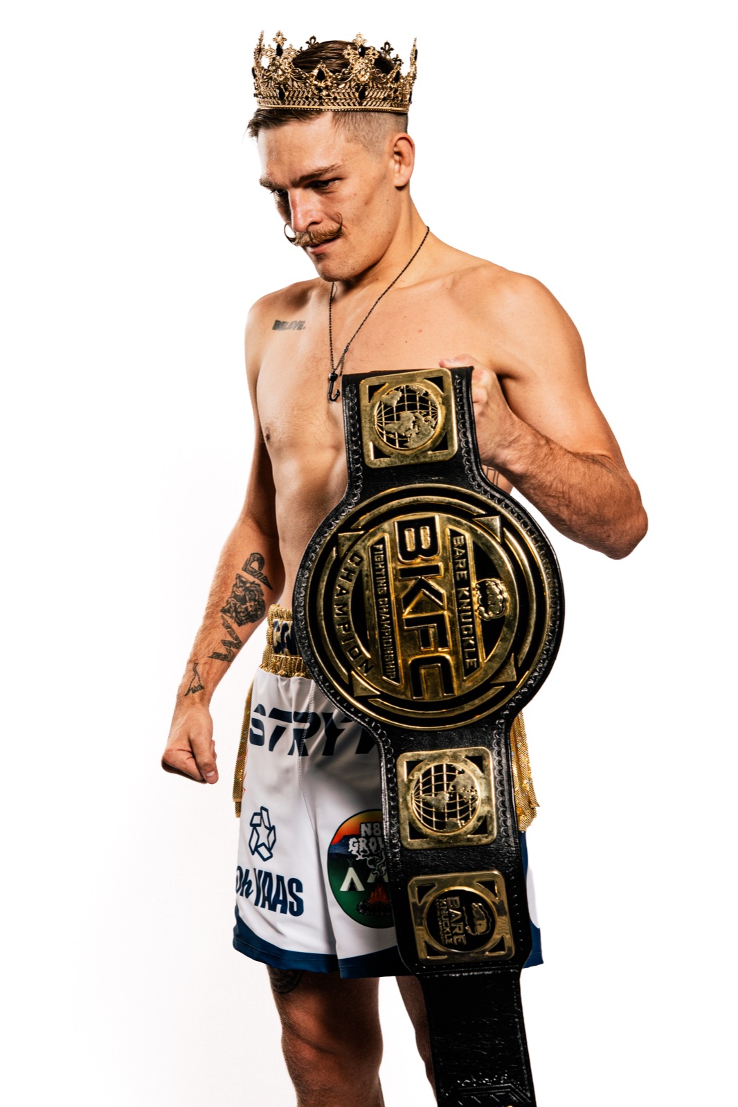 Kai Stewart wearing the crown and holding the BKFC featherweight world title belt